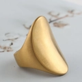 Dettaglio macro di un anello ovale a scudo dorato con finitura in metallo spazzolato - US 6 / Oro 18k