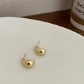 Minimalist gold pea stud earrings with polished curved surface on a wooden table - Large Gold Bean