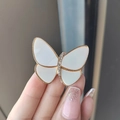 Elegant gold butterfly brooch with white wings and sparkling rhinestones held by hand - White Butterfly (XZ0110)