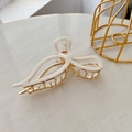 Detailed close-up of cream-colored acetic acid bow hair claw with gold metal finish - 11.5CM / Pearl White