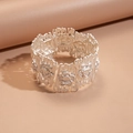 Détail d'un large bracelet argenté avec motifs floraux en relief et texture écorce - Style de fleur en relief en argent