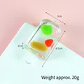 Fruit popsicle keychain model with colorful slices inside on a pink and white background - Raisin