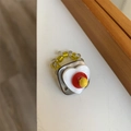 Detail eines handgefertigten Perlenrings mit geschichtetem Herzmotiv und gelben Perlen - Stil D Quadratische Muschel + Weißes Herz