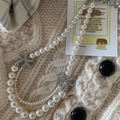 Details einer eleganten zweilagigen Perlenkette mit glitzernden Strass-Schleifen-Akzenten - Doppellagige Schleifen Halskette / Silber-Weiß