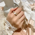 Elegant gold bead and white flower ring displayed on a model in a soft minimalist style - Small Flower Shell