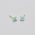 Detail of four-leaf flower studs with sky blue zircons and golden base on grey background - Gold Color Sky Blue Zirconia