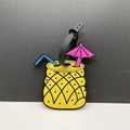 Pineapple-shaped luggage tag with blue straw and pink umbrella on yellow silicone - Pineapple Style