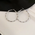 Makro-Detail großer silberner Creolen mit einer gedrehten, strukturierten Metalloberfläche - Silbernadel Spiral Twist Hoop