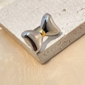 Two-tone bow ring in gold and silver finish on textured stone and silk background - Two-tone Bowknot Shape Ring