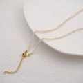 Mini freshwater pearl necklace with gold extender chain on white ceramic plate - Flat Round Beads