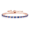 Close-up of rose gold adjustable bracelet featuring blue baguette-cut crystals - Rose Gold + Royal Blue Stone