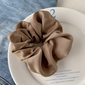 Coffee brown silk scrunchie with lace bow detail displayed on a vintage plate - High Satin Camel