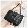 Classic black quilted chain shoulder bag with metal turn-lock on a beige coat surface - Black