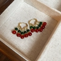 Primer plano de pendientes vintage de oro con perlas de cristal rojas y verdes en caja - Cuentas Vintage Rojas y Verdes Doradas (5#)