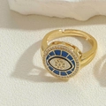 Detail eines vergoldeten Evil-Eye-Rings mit Zirkon-Blumen auf strukturiertem Stein - Königsblauer Zirkonia Ring (JZ0379-4)