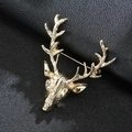 Macro view of a gold-tone reindeer head brooch on a textured black leather background - Gold Metal Deer