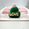Détail d'un mini bonnet en tricot vert avec pompon blanc et lettrage LOVE doré - Pompon Blanc / Vert (Design LOVE)