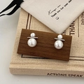 Detail shot of double pearl earrings on dark wood stand with vintage book background - Silver Large and Small Pearl Stud Earrings