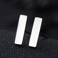 Close-up of minimalist rectangular bar stud earrings in polished stainless steel silver - Rectangle / Silver