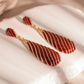 Detalle de pendientes de gota dorados con esmalte rojo oscuro y patrones de cebra oblicuos - Estilo de Gota de Aceite Rojo (Pin de Plata)