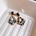 Dettaglio orecchini geometrici a rombo con acetato marmorizzato nero bianco e oro - Stile a Rombo Geometrico Nero Oro con Ago in Argento