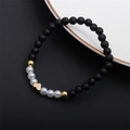Detail of beaded bracelet with black matte beads, faux pearls and golden heart charm - Matte Heart