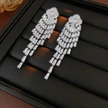 Close-up of elegant long silver tassel earrings with sparkling zircon stones on black stand - Silver
