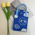 Detail of blue knitted phone bag with white cloud and cute cartoon sheep pattern - Little Lamb Blue