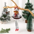 Weihnachtsbär-Anhänger aus Plüsch mit Feliz Navidad Schild an einem rustikalen Ast - Bär