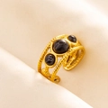 Detailed shot of retro gold-plated ring with black marble stones and woven texture - Gold-Black Stone
