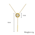 Dettaglio del ciondolo dorato con numeri romani, nappa da 6cm e peso di 4,1g mostrato - Oro
