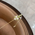Close-up of golden vintage hair stick with white resin flowers, pearls, and long tassels - Flowers on Branch - White