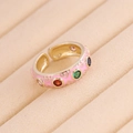 Macro shot of gold adjustable ring with pink enamel and colorful zircon gemstone inlays - Adjustable Open / Pink