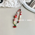 Dettaglio del cinturino per cellulare con ciondolo a ciliegia e perline a fragola - Ciliegia