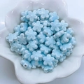 Dettaglio di perline in ceramica a fiori azzurri in un contenitore bianco per gioielli - Blu lago chiaro