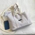 Borsa tote minimalista in tela color avena con etichetta fashion su sfondo bianco - Bianco Sporco