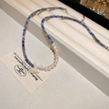 Détail du collier avec perles bleues facettées, perles blanches et pendentif papillon - Collier N° 38 - Bleu