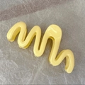 Close-up of a yellow wavy hair claw clip with a glossy finish on a gray textured surface - Dopamine Yellow