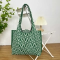 Detail of green and white patterned knit tote bag hanging on a minimalist white chair - Wave Green