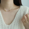 Collana minimalista in acciaio al titanio dorato con croce e zircone su maglione bianco - Collana a Croce / Oro