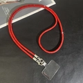 Detail view of luxurious red rhinestone phone strap with silver buckle on black background - Red