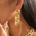 Nahaufnahme einer klobigen goldfarbenen Gliederkette und passenden Ohrringen am Modell - Ohrhänger - Gold (Silbernadel)