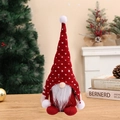 Gnomo di Natale con cappello lavorato a maglia rosso e bianco su tavolo di legno - Rosso