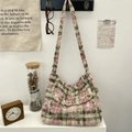 Detailed view of tie-dye plaid canvas hobo bag with vintage button accents and wide strap - Pink