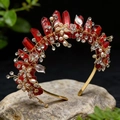 Detailopname van gouden bloemenkroon met roze kristallen en parels op een steen - Rood Kristal Gouddraad Gouden Bloem