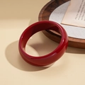 Close-up of deep red resin geometric round bangle on a vintage paper background - Wine Red Smooth Wide Style