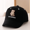 Close-up of cute bear embroidery and white letter stitching on a black cotton baseball cap - Black