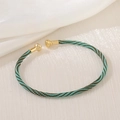 Macro detail of hand-woven green and brown cord bracelet with polished gold metal ends - Green Brown