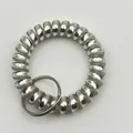 Silver metallic matte spiral wristlet with steel key ring on grey textured surface - Metallic White