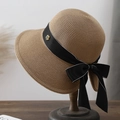 Cappello di paglia elegante con fiocco bianco e nero e logo camelia dorata su supporto - Cachi